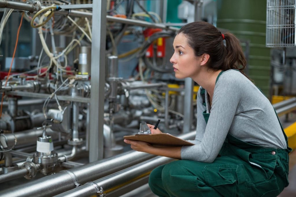 Operária mantendo registro na área de transferência na fábrica