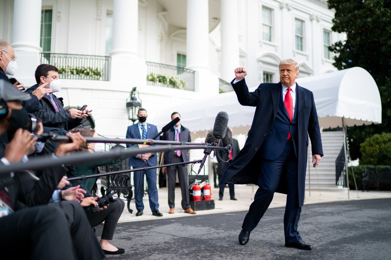 President Donald J. Trump gives a fist bump to the press Friday, Oct. 30, 2020, prior to boarding Marine One en route to Joint Base Andrews, Md. to begin his trip to Michigan, Wisconsin and Minnesota. (Official White House Photo by Tia Dufour)