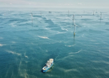 IEA: investimento em energia volta a crescer em 2021, mas distante de rota de neutralidade de carbono. Na imagem: Embarcação próxima a turbinas eólicas offshore, em mar azul com pequenas ondas pelo vento (Foto: GWEC)