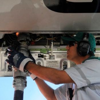 Combustível do Futuro define proposta para descarbonizar a aviação. Na imagem: Homem branco conecta, à parte de baixo de aeronave, mangueira para abastecimento de aeronave com SAF, biocombustível de aviação (Foto: Tânia Rêgo/Agência Brasil)