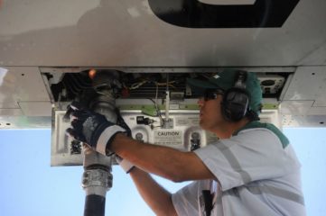 Combustível do Futuro define proposta para descarbonizar a aviação. Na imagem: Homem branco conecta, à parte de baixo de aeronave, mangueira para abastecimento de aeronave com SAF, biocombustível de aviação (Foto: Tânia Rêgo/Agência Brasil)