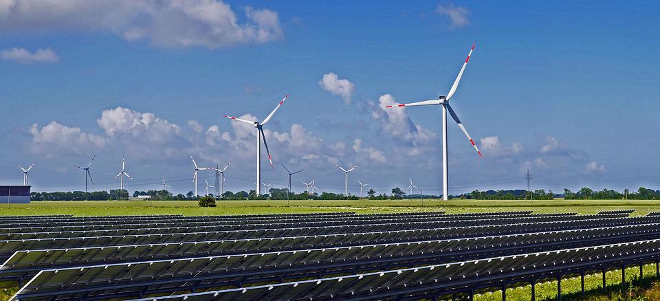 Novos rastreadores mapeiam a construção global de energia solar e eólica. Na imagem: Parque solar (com fileiras de placas fotovoltaicas em primeiro plano e vistas da parte de trás) e eólico (com sequência de aerogeradores ao fundo, em segundo plano) (Foto: Erich Westendarp/Pixabay)