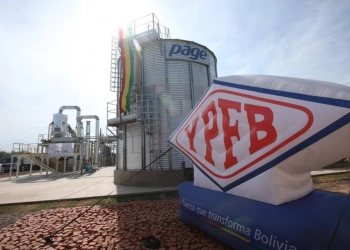 Brasileiras buscam espaço para importar gás boliviano. Na imagem: Placa escrita YPFB e tanque de armazenamento na cor prata com faixa pendurada nas cores da bandeira da Bolívia: vermelho, amarelo e verde (Foto: Divulgação YPFB)