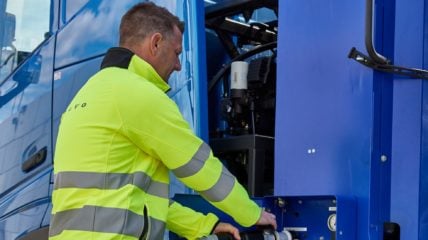 Como será a energia da América Latina em 2050? Na imagem: Caminhão elétrico azul da Volvo conectado a carregador elétrico por trabalhador com uniforme amarelo. Volvo apresenta na Europa e EUA caminhão com células de combustível a hidrogênio, com zero emissões (Foto: Divulgação)