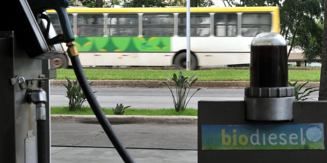 Indústria recorre à ANP para adiar importação de biodiesel. Na imagem: Bomba em posto com abastecimento de biodiesel; e ao fundo ônibus urbano passando (Foto: Agência Brasil)