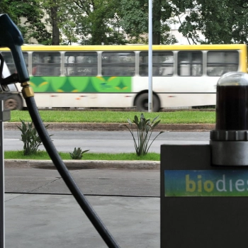 Indústria recorre à ANP para adiar importação de biodiesel. Na imagem: Bomba em posto com abastecimento de biodiesel; e ao fundo ônibus urbano passando (Foto: Agência Brasil)