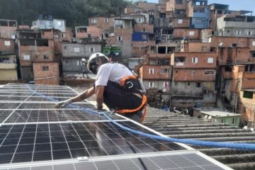 Programa quer priorizar GD renovável para baixa renda. Na imagem: Técnico, equipado com itens de segurança, instala placas fotovoltaicas para energia solar sobre telhado em favela de SP (Foto: Instituto Favela da Paz)