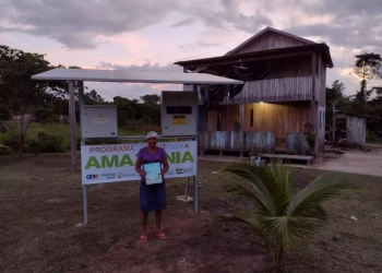 Na imagem: Mulher segura conta de luz e sorri. Programa Mais Luz Para a Amazônia leva energia elétrica a comunidades em áreas remotas (Foto: Divulgação/Energisa)