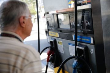 Preço da gasolina vai subir ou cair? Veja como varia o ICMS no seu estado. Na imagem: Homem olhando visor de bomba de combustíveis (Foto: Fernando Frazão/Agência Brasil)