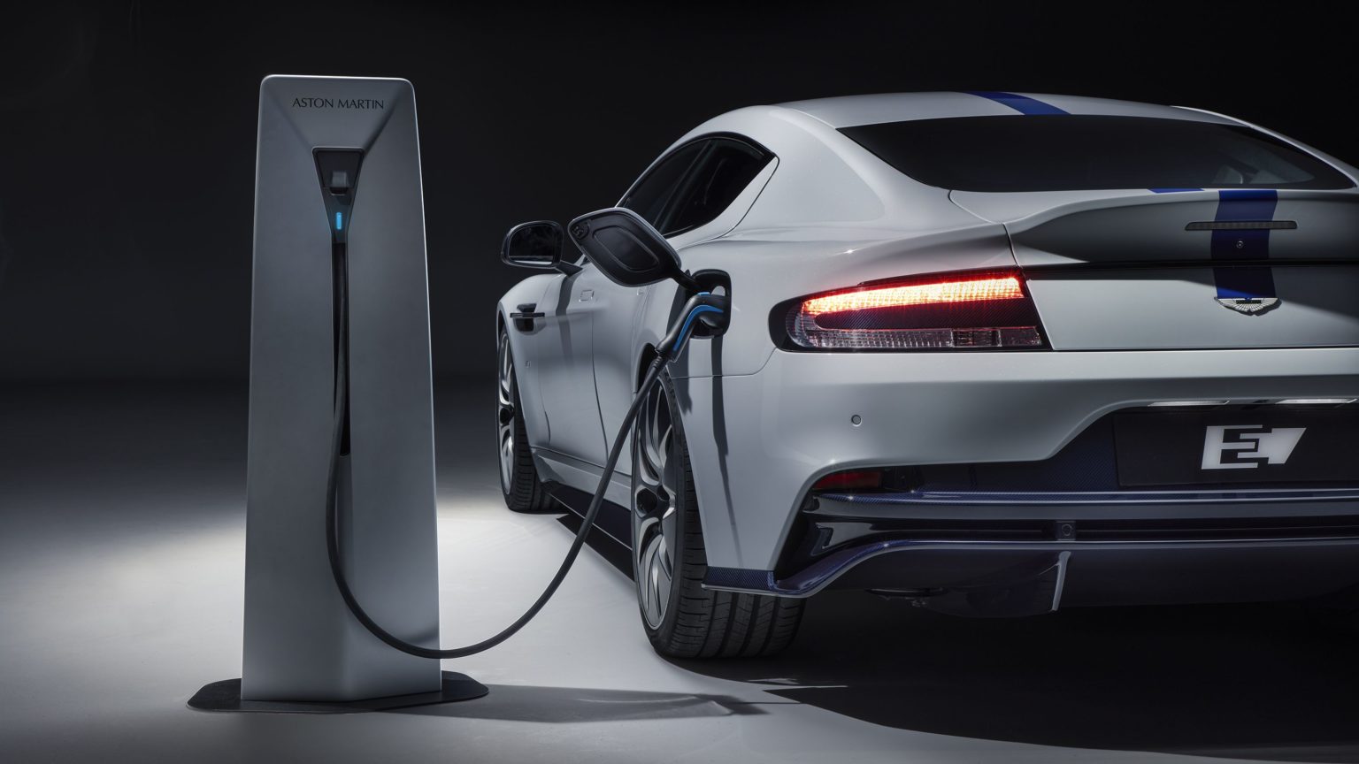 Aston Martin e Lucid fecham parceria para fabricar carros elétricos. Na imagem: Veículo elétrico esportivo Aston Martin, na cor prata, conectado à base para recarrega (Foto: Divulgação)