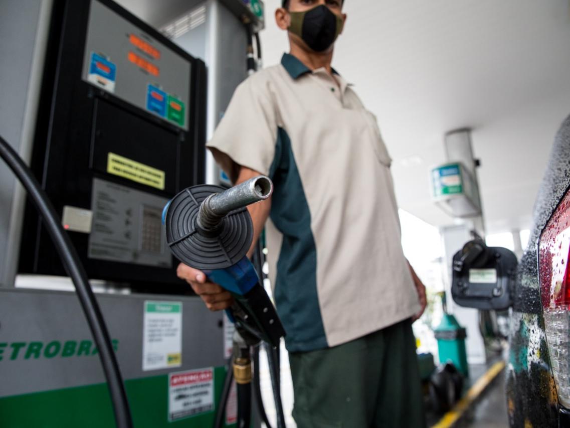 Petróleo sustenta alta no exterior e gasolina recua no Brasil. Na imagem: Frentista segura bomba de abastecimento em posto de combustíveis, apontando o bico para a câmera; ao lado, um veículo preto (Foto: Divulgação Petrobras)