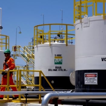 Petrobras reduz preços de gasolina e do GLP para as distribuidoras a partir de sábado (1/7). Na imagem: Trabalhadores de uniforme laranja passam em frente a tanques de armazenamento de combustíveis em planta da PBIO – Petrobras Biocombustível (Foto: Divulgação PBIO)