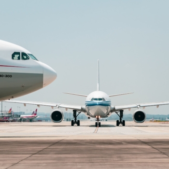 Visão lateral da parte frontal de aeronave e, ao fundo, visão frontal de outro avião, em pista de aeroporto (Foto: 穿着拖鞋一路小跑/Pixabay)