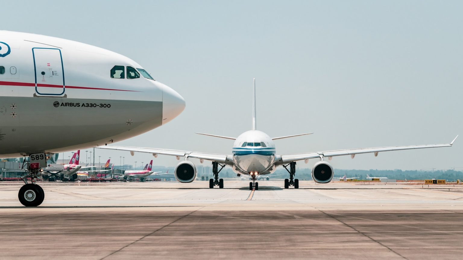 Visão lateral da parte frontal de aeronave e, ao fundo, visão frontal de outro avião, em pista de aeroporto (Foto: 穿着拖鞋一路小跑/Pixabay)