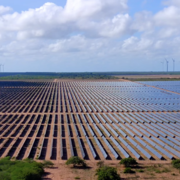 Usina solar fotovoltaica Serra do Mel da Voltalia, com turbinas eólicas ao fundo (Foto: Divulgação)