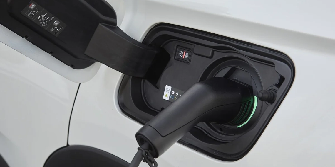 Grandes montadoras planejam rede conjunta de recarga de carros elétricos. Na imagem: Plug de recarga, preto, conectado a veículo elétrico branco