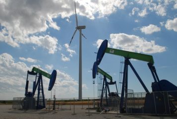 Mundo vai passar por falta de petróleo? E os alertas de subinvestimento no O&G. Na imagem: Cavalos-de-pau para exploração onshore de petróleo e turbina eólica (Foto: Wiki Commons)