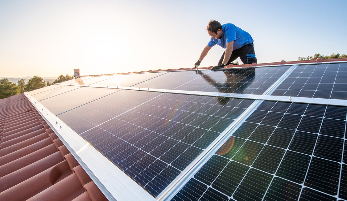 Passo a passo: Saiba como aderir à geração distribuída de energia. Na imagem: Técnico instala painéis solares fotovoltaicos sobre telhado residencial