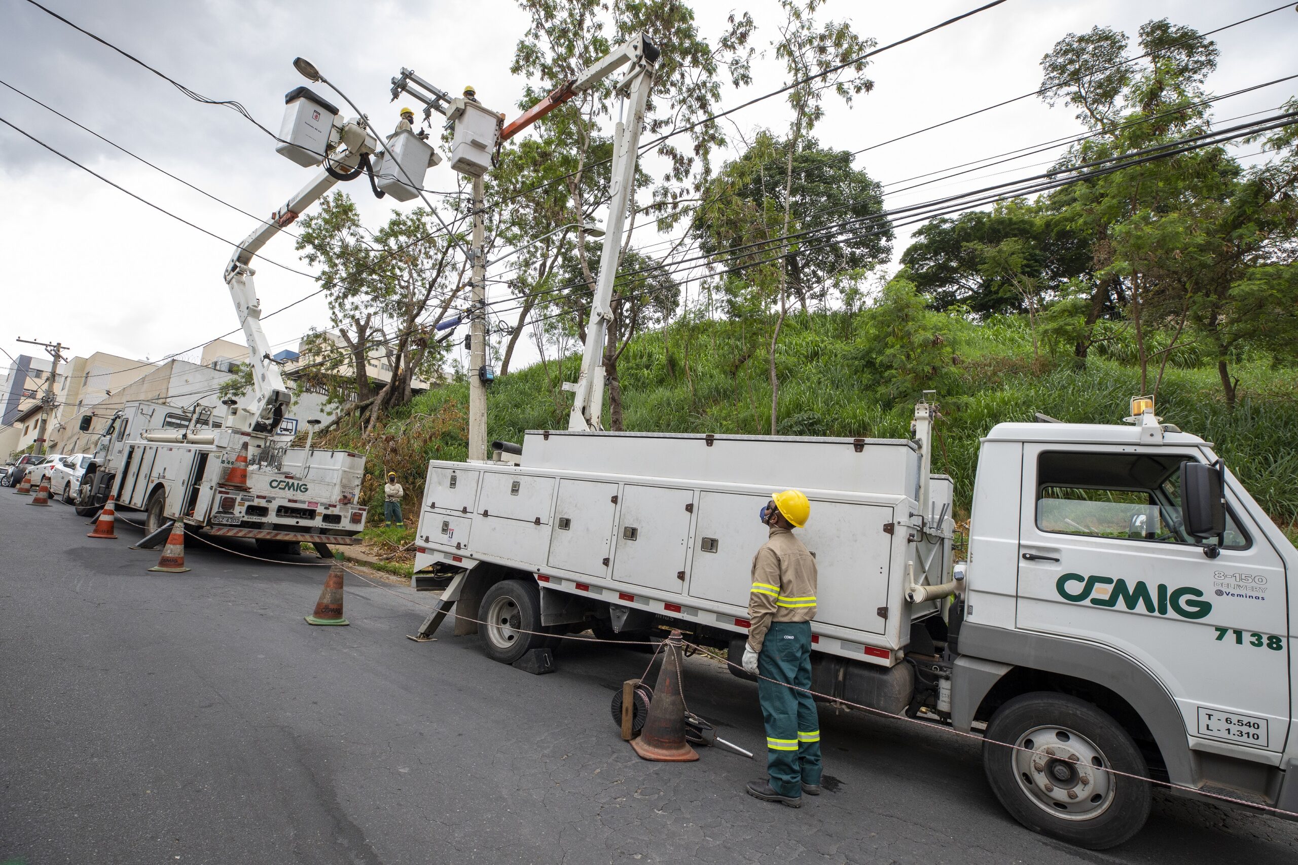 Cemig abre concurso público para mais de 200 vagas de nível médio e superior. Na imagem: Três técnicos em dois caminhões da Cemig fazem reparos na rede elétrica (Foto: Divulgação)