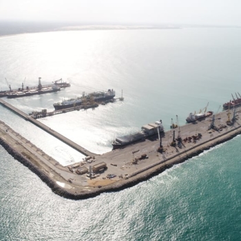 Ceará se junta a eólica, solar e biogás em pacto brasileiro do hidrogênio renovável. Na imagem: Vista aérea de embarcações no cais do porto do Pecém, com sol refletindo no mar na coloração "prateada" (Foto: Divulgação CIPP)