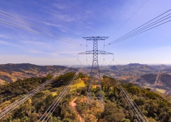 Entenda que está em jogo na criação do mercado livre de energia elétrica e principais impactos para o setor. Na imagem: Sistema de transmissão de energia Cantareira, entre MG e SP, da Elecnor do Brasil. Linhas de transmissão, em primeiro plano, e torre de grande porte, ao fundo, com céu azul (Foto: Divulgação)