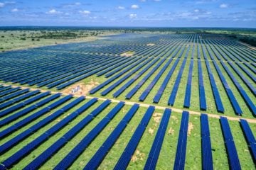 Vista aérea de grande extensão de fileiras de módulos fotovoltaicos instalados sobre gramado; Usina solar fotovoltaica (UFV) Assuruá, comprada pela Atiaia Renováveis, localizada no município de Itaguaçu na Bahia (Foto: Divulgação)