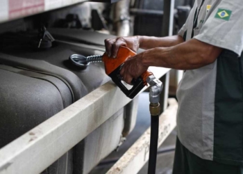 Mão de frentista segura gatilho e abastece tanque de caminhão a diesel em posto da Petrobras (Foto Divulgação Scania)