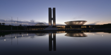 Esforço concentrado no Senado e na Câmara para aprovação do Combustível do Futuro e definições do setor de energia. Na imagem: Congresso Nacional fotografado ao anoitecer, com cúpulas e torre central, ao fundo, refletidas no espelho d'água, em primeiro plano (Foto Edilson Rodrigues/Agência Senado)