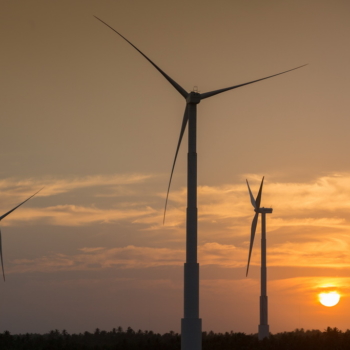 Contratos de arrendamento de terras para projetos eólicos têm desequilíbrios que afetam pequenos proprietários rurais, mostra estudo do Inesc. Na imagem: Usina de Energia Eólica (UEE) em Icaraí, no Ceará, com pôr do sol ao fundo (Foto: Ari Versiani/PAC)