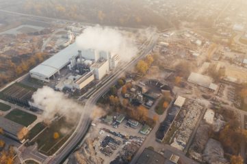 Menos de uma em cada cinco grandes empresas está em direção à meta net zero. Na imagem: Vista aérea de emissões poluentes sendo lançadas na atmosfera em complexo industrial, em uma grande cidade (Foto: Marcin Jozwiak/Pixabay)