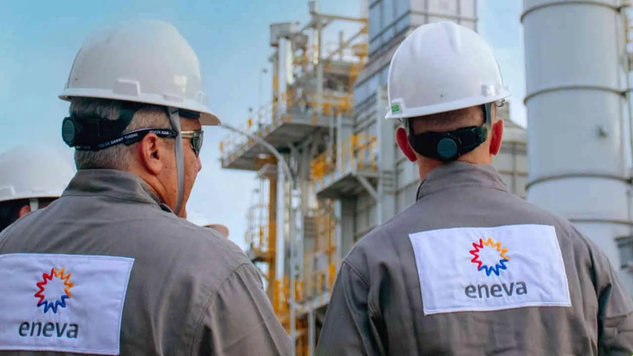 Eneva propõe fusão com a Vibra e espera acelerar a interiorização e as vendas de gás natural. Na imagem: Planta da Eneva com dois trabalhadores (homens da cor branca), fotografados de costas conversando, com uniformes cinza e capacetes de proteção brancos (Foto: Divulgação)