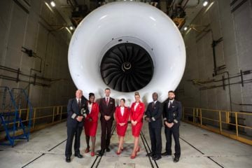 Tripulação em frente a turbina da aeronave Boeing 787, com motor Rolls-Royce Trent 1000, que fará o voo com 100% de SAF de Londres a Nova Iorque (Foto: Virgin Atlantic)