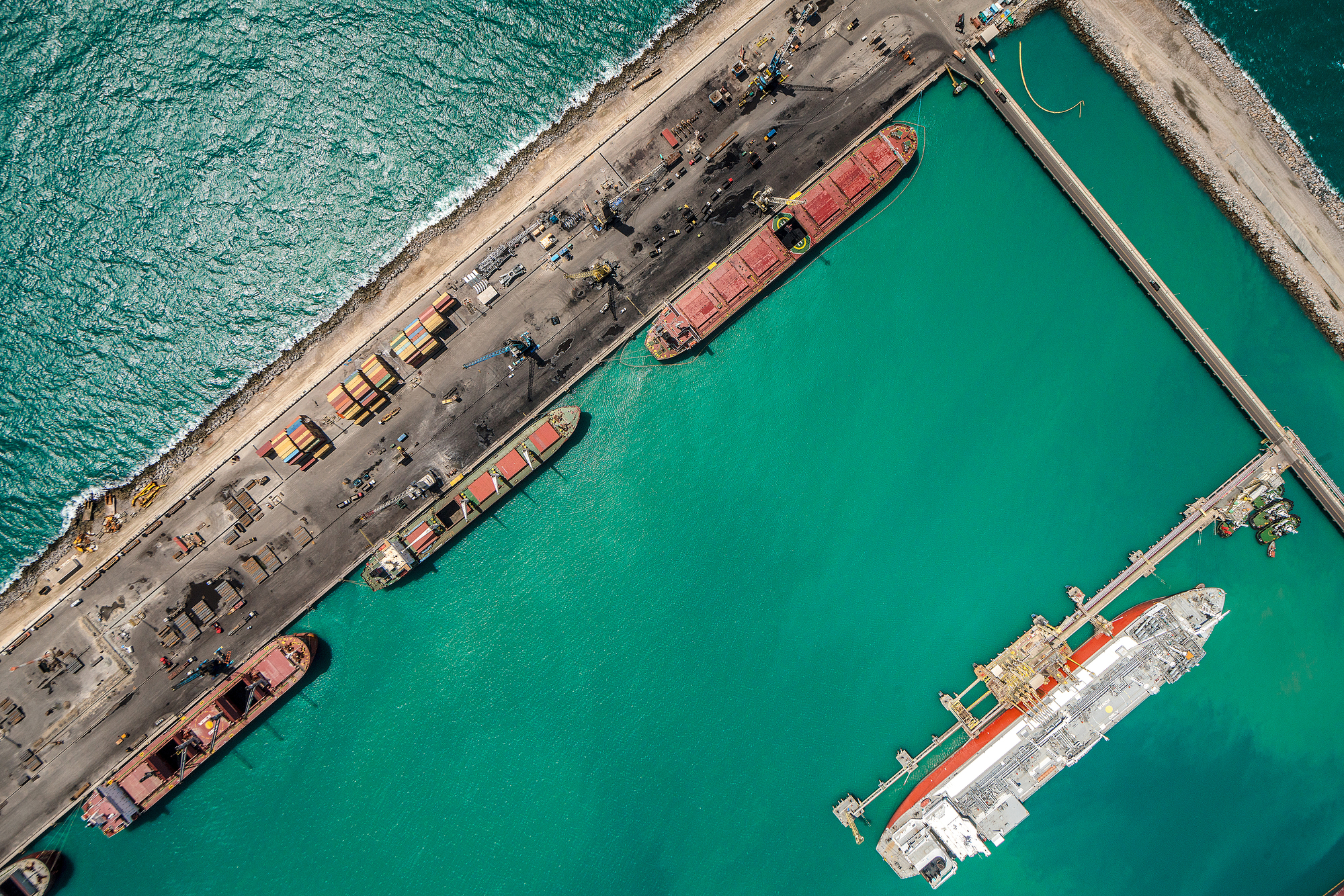 Ceará libera primeira licença ambiental a uma empresa de hidrogênio verde, a australiana Fortescue. Na imagem: Vista aérea vertical de embarcações atracadas no cais do Porto do Pecém, com água esverdeada ao redor (Foto: Divulgação)