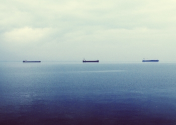 Três navios tanque petroleiros navegam em mar azul e calmo na cidade de Tessalônica, Grécia (Foto John Maravelakis/Unsplash)