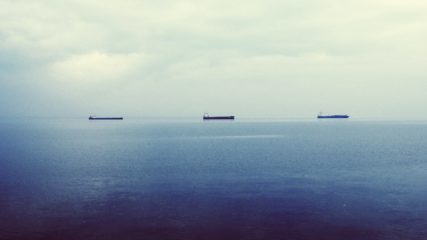 Três navios tanque petroleiros navegam em mar azul e calmo na cidade de Tessalônica, Grécia (Foto John Maravelakis/Unsplash)