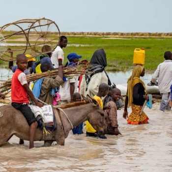 Refugiados climáticos: moradores de Rann, no nordeste da Nigéria, caminham pela estrada principal inundada, inacessível para veículos; Milhões de pessoas enfrentam a fome e as vidas de crianças estão em risco no nordeste da Nigéria, em meio a um conflito prolongado e da intensificação das alterações climáticas (Foto: Christina Powell/Ocha)