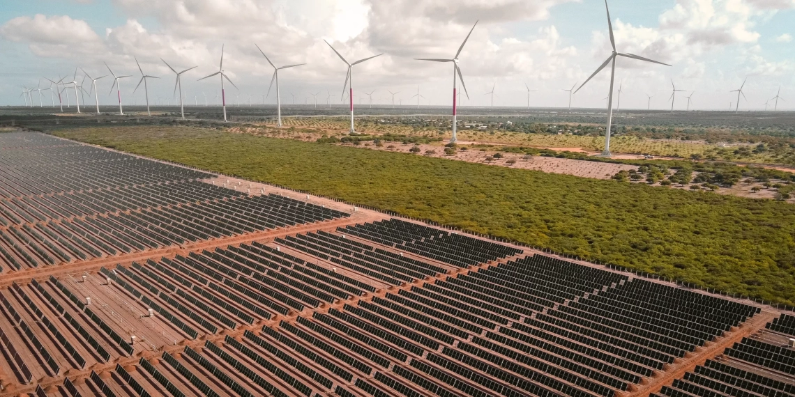 Brasil instala 7GW de eólica e solar até outubro de 2023. Na imagem: Vista de usina híbrida eólica e solar fotovoltaica, com inúmeras fileiras de módulos fotovoltaicos, em primeiro plano, e aerogeradores, ao fundo, à direita (Foto: Divulgação Voltalia)