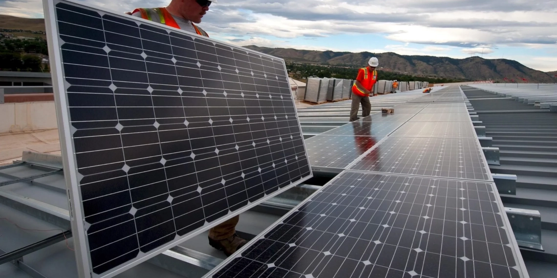 Imposto sobre painéis solares importados é "retrocesso" e afeta 85% dos projetos no Brasil, diz Absolar. Na imagem: Trabalhadores instalam painéis fotovoltaicos sobre uma longa extensão; vestem colete de proteção laranja e capacetes brancos com lanternas acopladas (Foto: Skeeze/Pixabay)