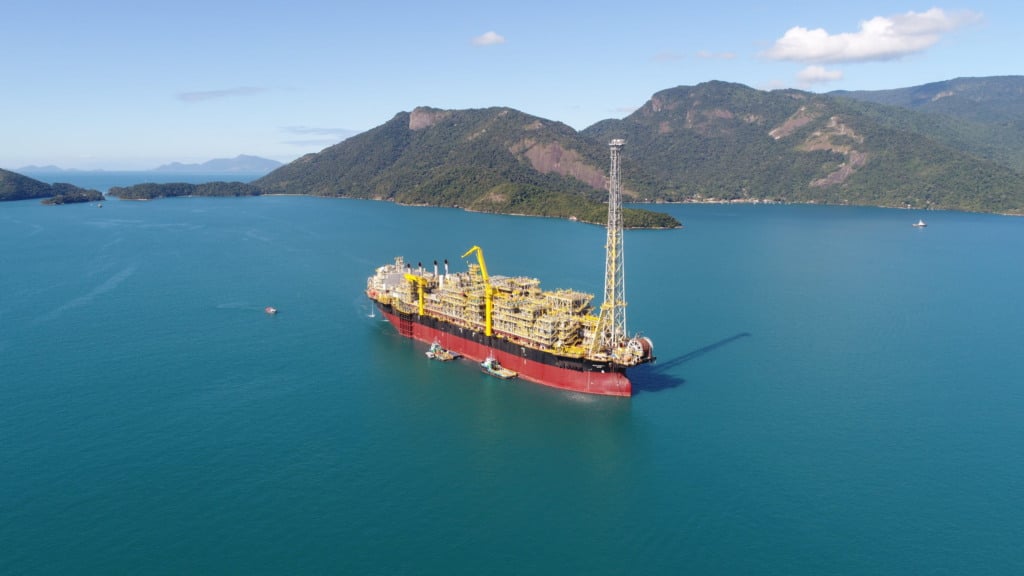 Banco Nacional de Desenvolvimento Econômico e Social (BNDES) seleciona consórcio para Planejamento Espacial Marítimo (PEM) no Sudeste. Na imagem: Vista de Navio-plataforma em alto mar com montanhas ao fundo. FPSO Carioca rumo ao campo de Sépia, na Bacia de Santos (Foto: Cortesia Modec)