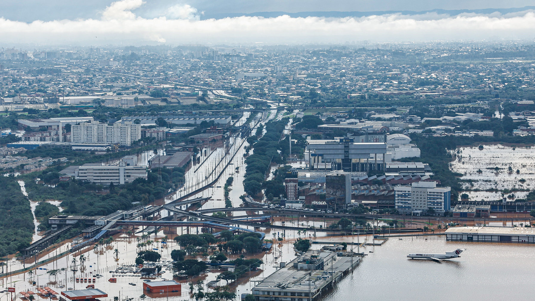 Refinaria Alberto Pasqualini (Refap), em Canoas (RS), retoma gradualmente escoamento de GLP, o gás de cozinha. Na imagem: Sobrevoo de área inundada com aeronave ilhada e estrada e aeroporto encobertos pelas águas das fortes chuvas em Canoas (RS), em 5/5/2024 (Foto: Ricardo Stuckert/PR)