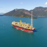 Plano Decenal de Expans&atilde;o de Energia (PDE) 2034 indica queda antecipada na produ&ccedil;&atilde;o de petr&oacute;leo. Na imagem: Vista de Navio-plataforma em alto mar com montanhas ao fundo. FPSO Carioca rumo ao campo de S&eacute;pia, na Bacia de Santos (Foto: Cortesia Modec)