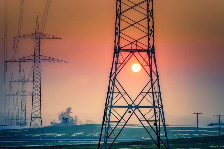 Consumo de energia elétrica cresceu 7% no primeiro semestre de 2024 puxado pelo maior uso de ar-condicionado durante ondas de calor, mostra CCEE. Na imagem: Torres de transmissão de energia elétrica de alta tensão com sol se pondo ao fundo (Foto: Albrecht Fietz/fietzfotos/Pixabay)