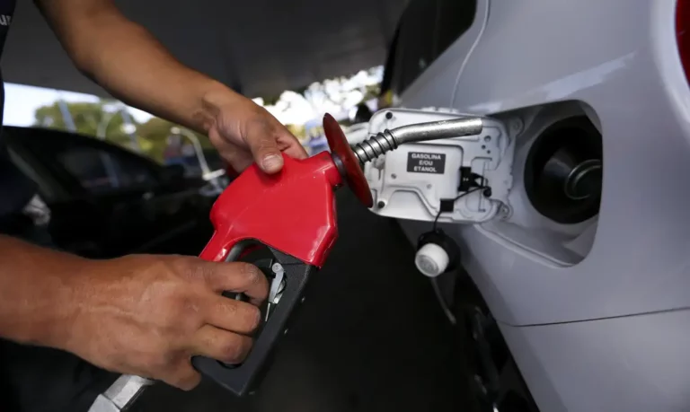 Decisão da ANP sobre recurso da formuladora Copape é adiada após pedido de vista de Fernando Moura. Na imagem: Mão de frentista segura bomba de abastecimento vermelha em posto de combustíveis próximo a abertura do tanque do automóvel (Foto Marcelo Camargo/Agência Brasil)