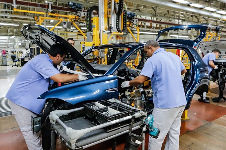 Trabalhadores e braços robóticos em linha de produção automotivas (Foto: Rodrigo Felix Leal/Seil)