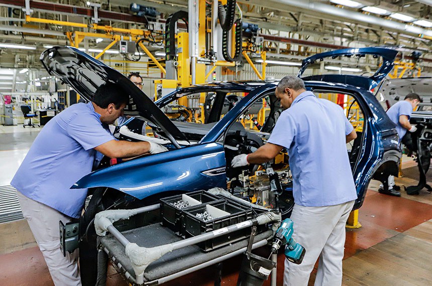 Trabalhadores e braços robóticos em linha de produção automotivas (Foto: Rodrigo Felix Leal/Seil)