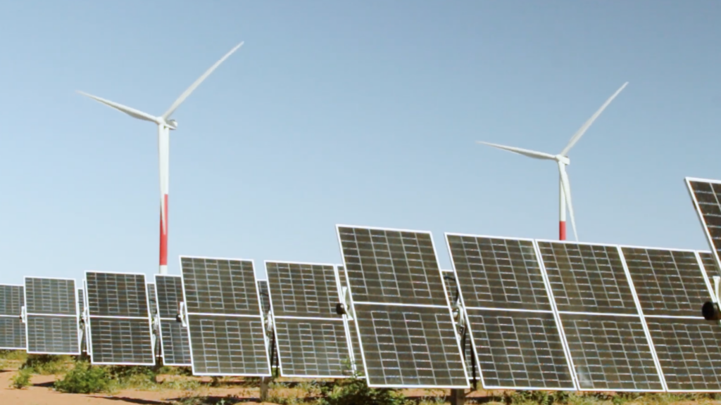 Usina solar fotovoltaica Serra do Mel da Voltalia, com painéis na vertical e turbinas eólicas ao fundo (Foto: Divulgação)