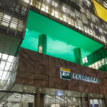 Procuradoria da ANP concorda com viabilidade judicial para processar Petrobras na disputa por abandono de poços órfãos. Na imagem: Fachada da sede da Petrobras (Edise), no Rio de Janeiro; iluminação do prédio em verde e amarelo (Foto Flávio Emanuel/Agência Petrobras)