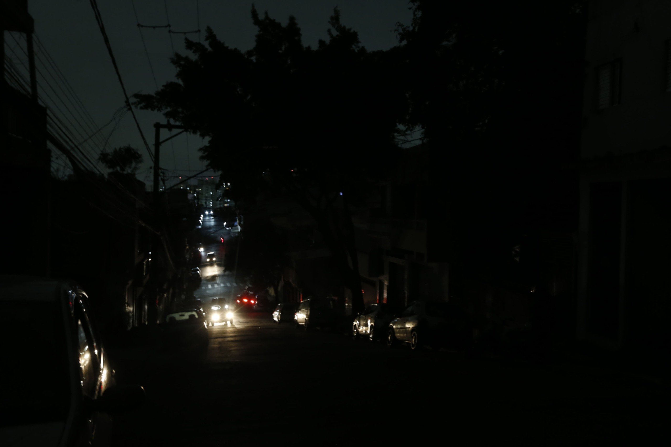 Luzes de faróis de veículos iluminam a Avenida Padre Arlindo Vieira, no bairro do Jabaquara em SP, sem energia elétrica, em 13/10/2024, devido a fortes chuvas (Foto Paulo Pinto/Agência Brasil)