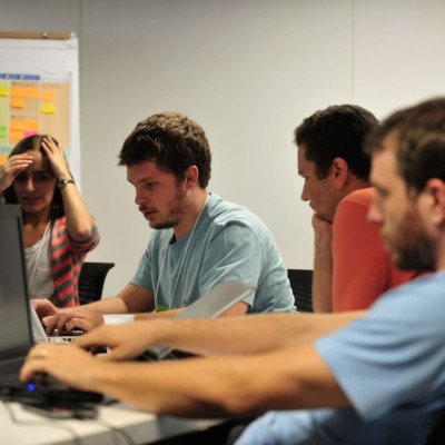 Três homens e uma mulher jovens reunidos em grupo utilizam notebooks durante o evento Startup Weekend Brasília, em 22/2/2014 (Foto Marcelo Camargo/Agência Brasil)