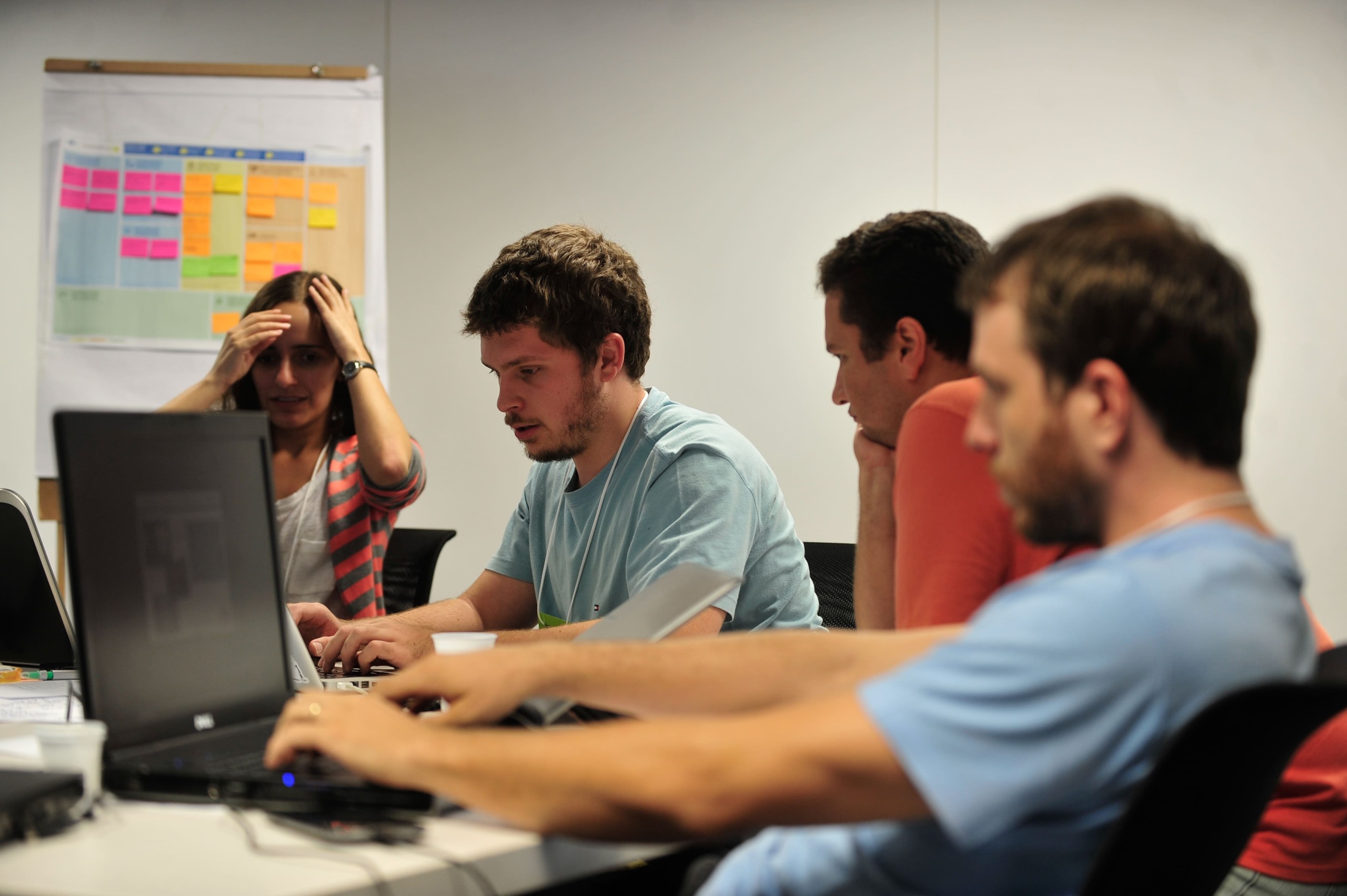 Três homens e uma mulher jovens reunidos em grupo utilizam notebooks durante o evento Startup Weekend Brasília, em 22/2/2014 (Foto Marcelo Camargo/Agência Brasil)